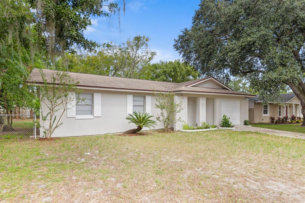 A single-story house with a light-colored exterior, a shingled roof, and a front lawn — 610 E HELM WAY, CASSELBERRY, FL