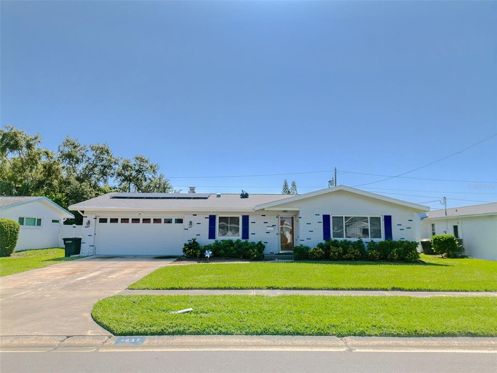 A single-story white brick house with a two-car garage and blue shutters — 1837 PRINCETON, CLEARWATER, FL