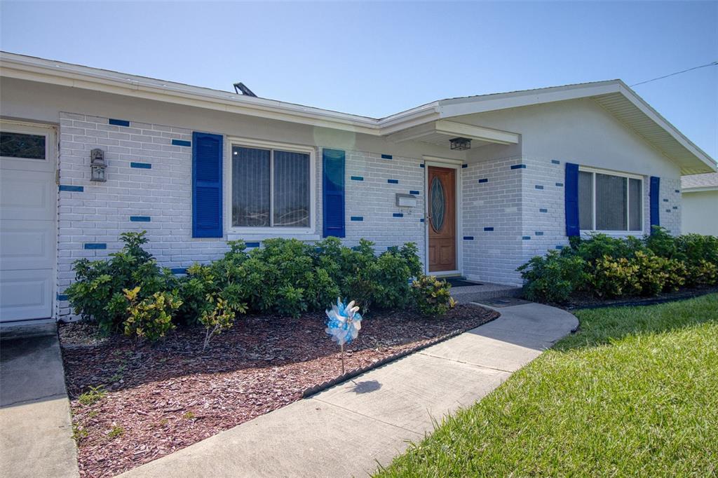 A single-story house with white brick walls, blue shutters, and a front walkway — 1837 PRINCETON, CLEARWATER, FL