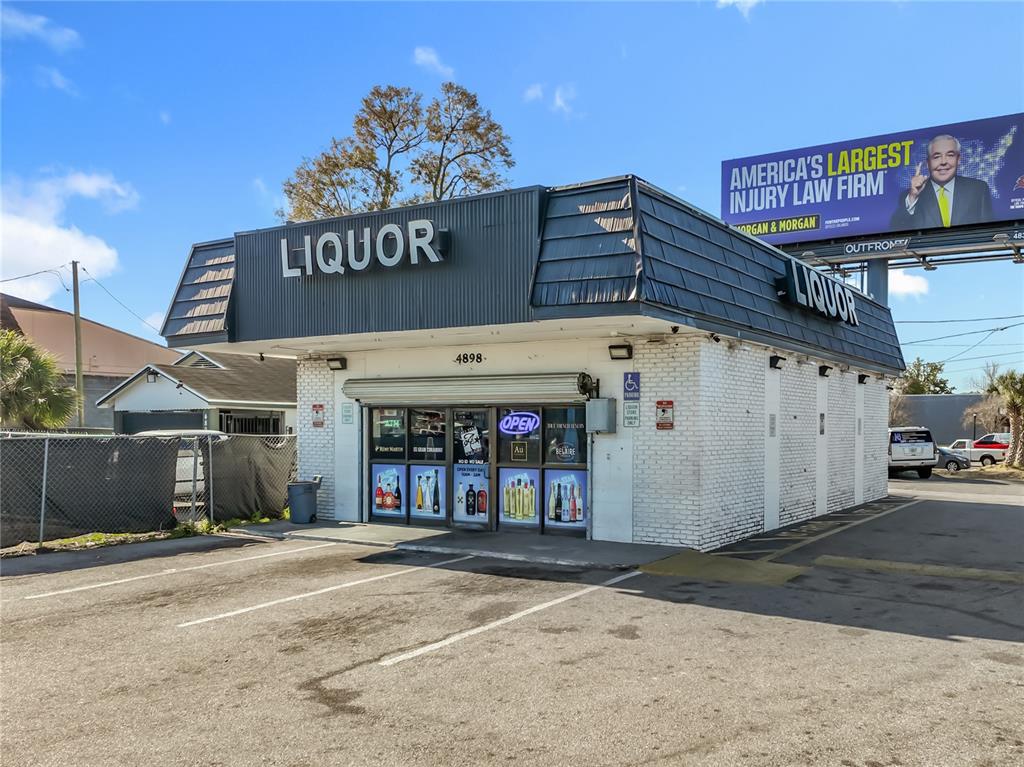 A single-story brick liquor store building with a dark metal mansard roof and parking lot — 4898 EDGEWATER DRIVE, ORLANDO, FL