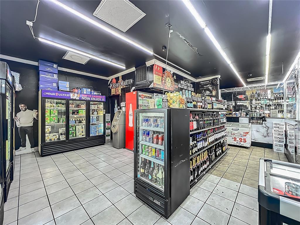 A liquor store interior features tiled floors, glass-front beverage coolers, and shelves stocked with alcohol — 4898 EDGEWATER DRIVE, ORLANDO, FL