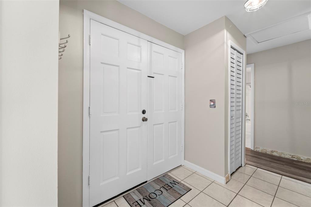 An entryway features white double doors, a welcome mat, and light-colored tile flooring — 1 WINDRUSH BOULEVARD UNIT 24, INDIAN ROCKS BEACH, FL