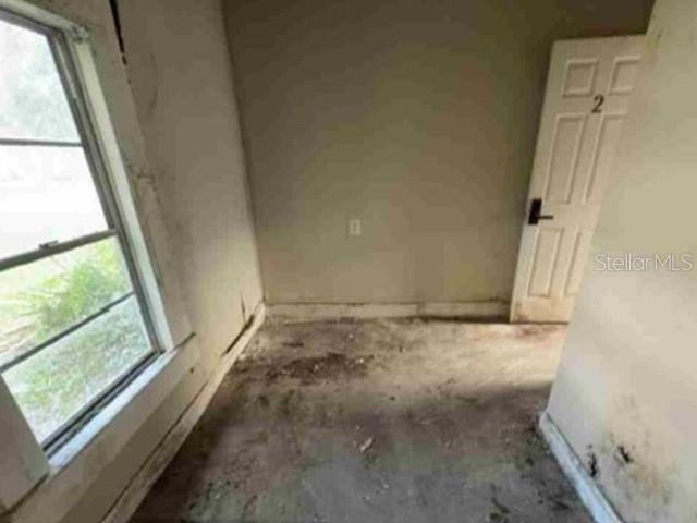 An empty, unfinished room features a window, a door labeled 2, and worn flooring — 2623 E 29TH AVENUE, TAMPA, FL