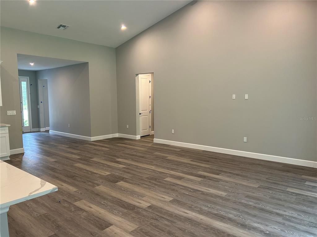 A living room features a wooden console table, a black coffee table, and neutral seating — 14 STATICE COURT, HOMOSASSA, FL