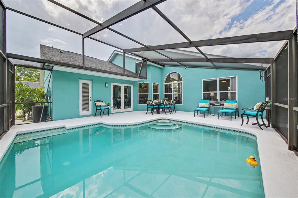 A teal single-story house with a white garage and a paved driveway under a blue sky — 1986 CRYSTAL DOWNS COURT, OVIEDO, FL