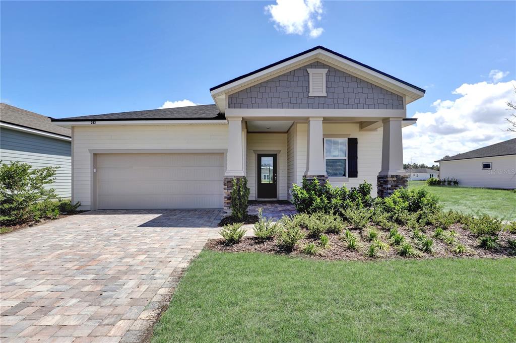 A single-story house with a paved driveway, a two-car garage, and a covered front porch — 310 KNOTTED BIRCH AVENUE, ST AUGUSTINE, FL