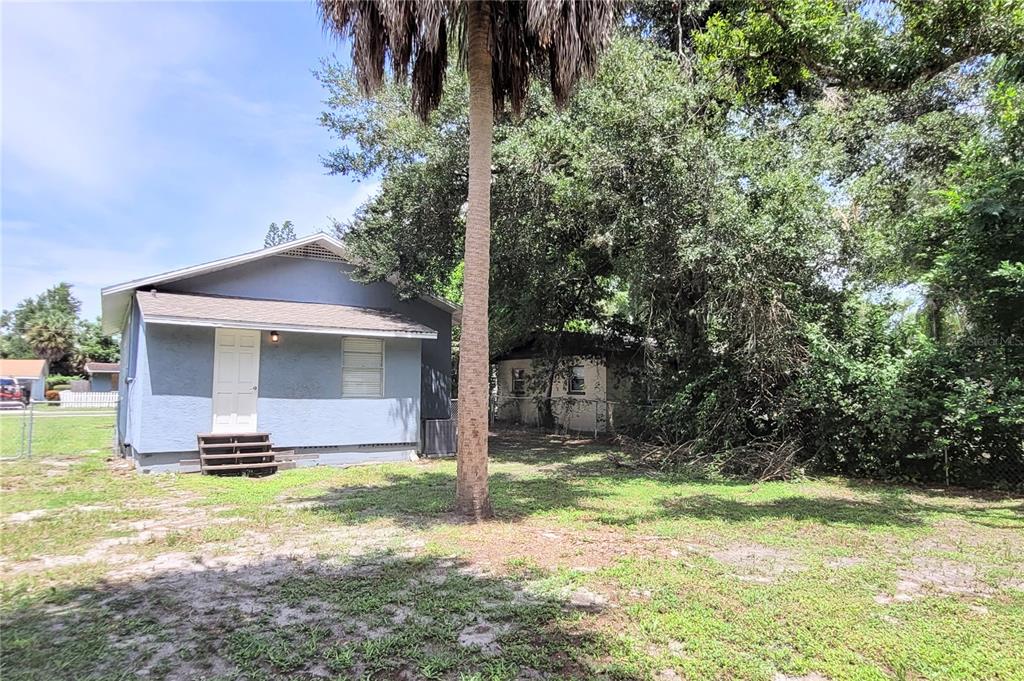 A light blue house with a white door and wooden steps sits on a grassy lot — 1542 29TH STREET, SARASOTA, FL