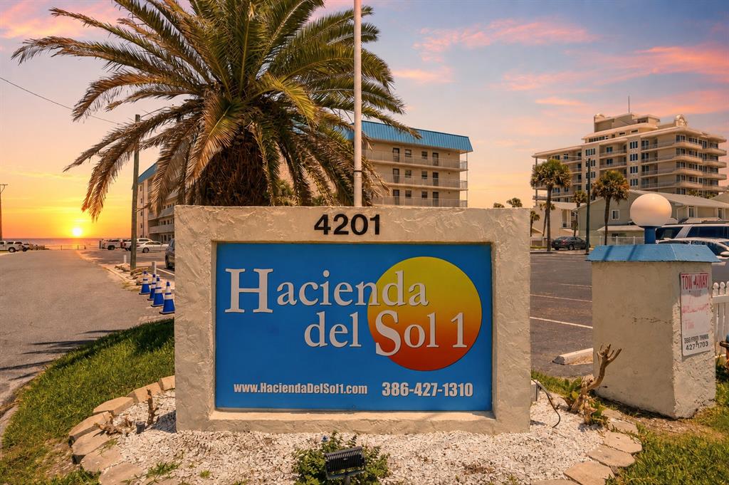 A sign for Hacienda del Sol 1 stands in front of a beachside apartment building — 4201 S ATLANTIC AVENUE UNIT 503, NEW SMYRNA BEACH, FL