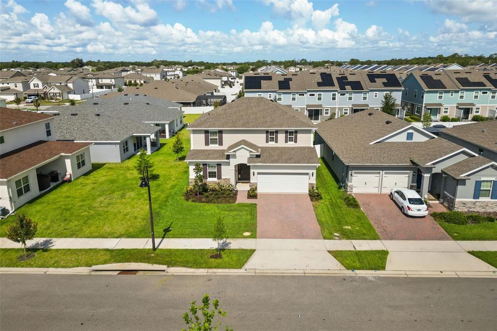 An aerial view shows a two-story suburban house with a paved driveway and green lawn — 1304 SILO DRIVE, ST CLOUD, FL