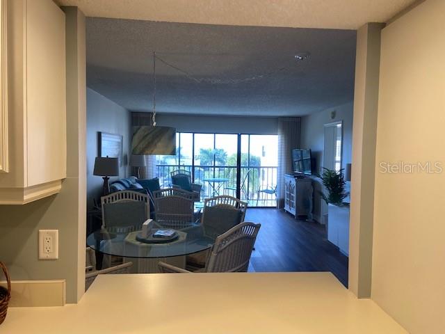 A view from a kitchen counter looking into a dining area and living room with balcony — 1001 BENJAMIN FRANKLIN DRIVE UNIT 507, SARASOTA, FL
