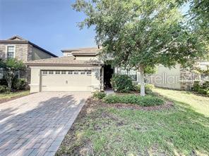 A kitchen features white cabinets, granite countertops, stainless steel appliances, and light-colored tile flooring — 1468 MOON VALLEY DRIVE, DAVENPORT, FL