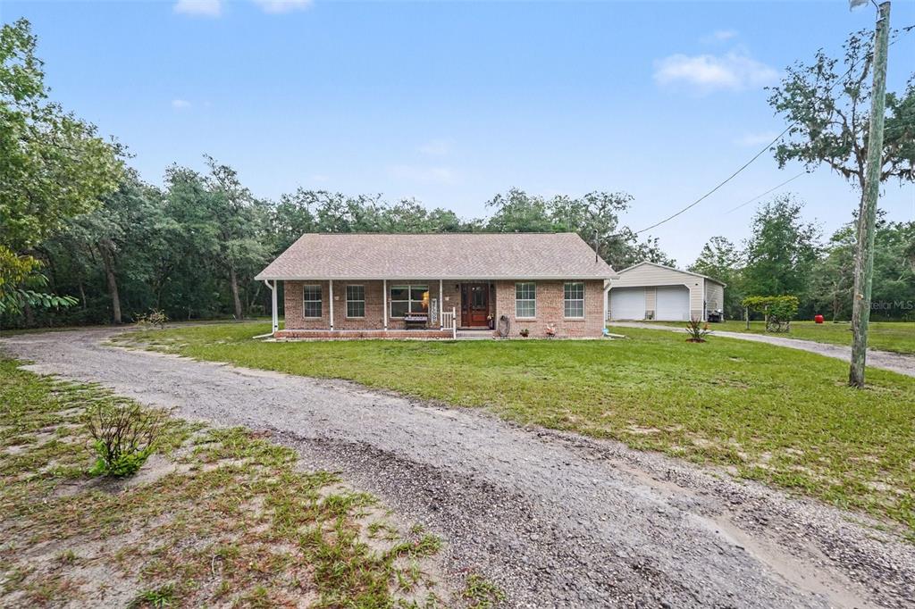 A single-story brick house with a front porch and a detached two-car garage — 9172 KEDRONE DRIVE, WEBSTER, FL