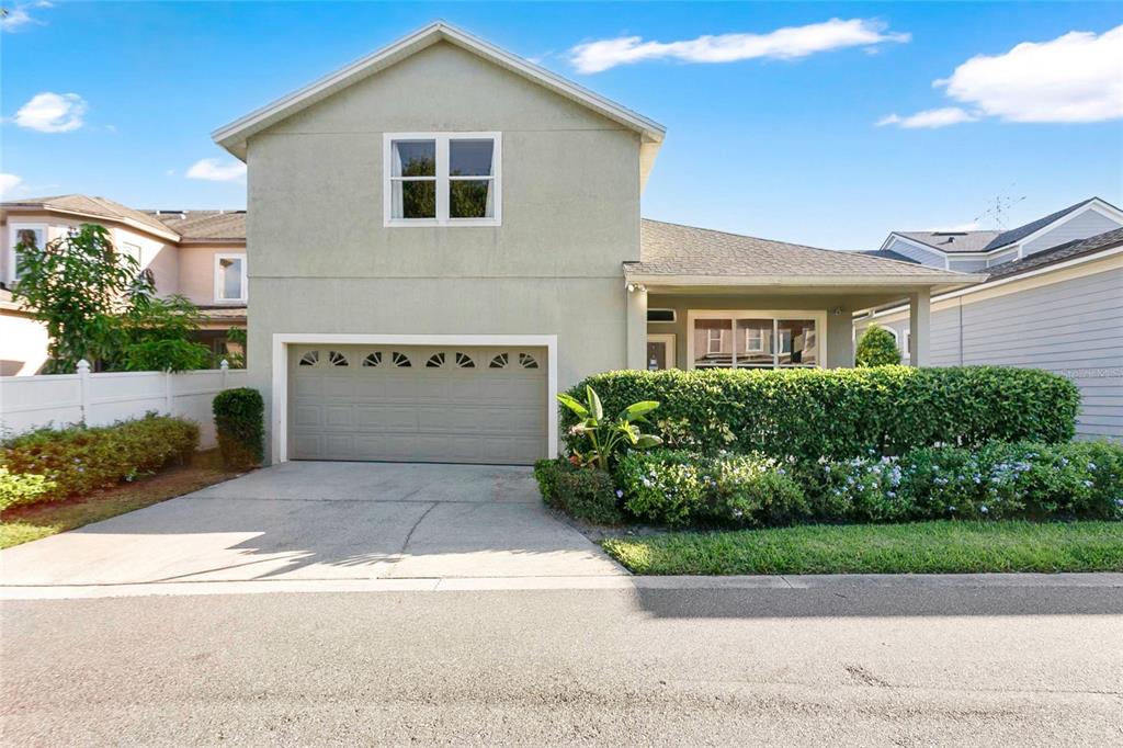 A two-story house features a light-colored stucco exterior, a single-car garage, and a landscaped front yard — 6712 THORNHILL CIRCLE, WINDERMERE, FL