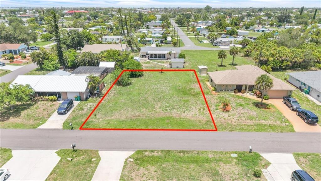 An aerial view shows a vacant, rectangular residential lot outlined in red between two houses — 1274 CORAL LANE, ENGLEWOOD, FL