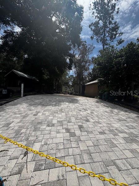A paved patio features a fire pit, outdoor chairs, and various potted plants — 25244 NE 143RD  ST UNIT 180, SALT SPRINGS, FL