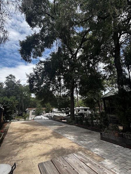 A Rockwood Signature Ultra Lite travel trailer is parked outdoors next to a golf cart — 25244 NE 143RD  ST UNIT 180, SALT SPRINGS, FL
