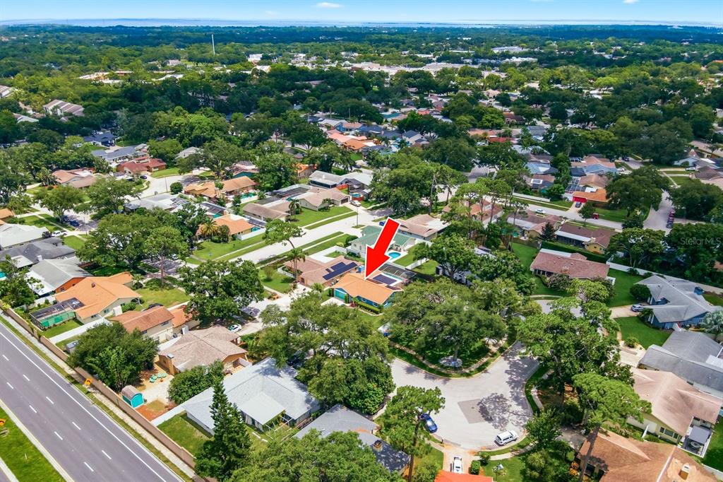 An aerial view shows a residential neighborhood with a red arrow pointing to a house — 3047 CASCADE DRIVE, CLEARWATER, FL