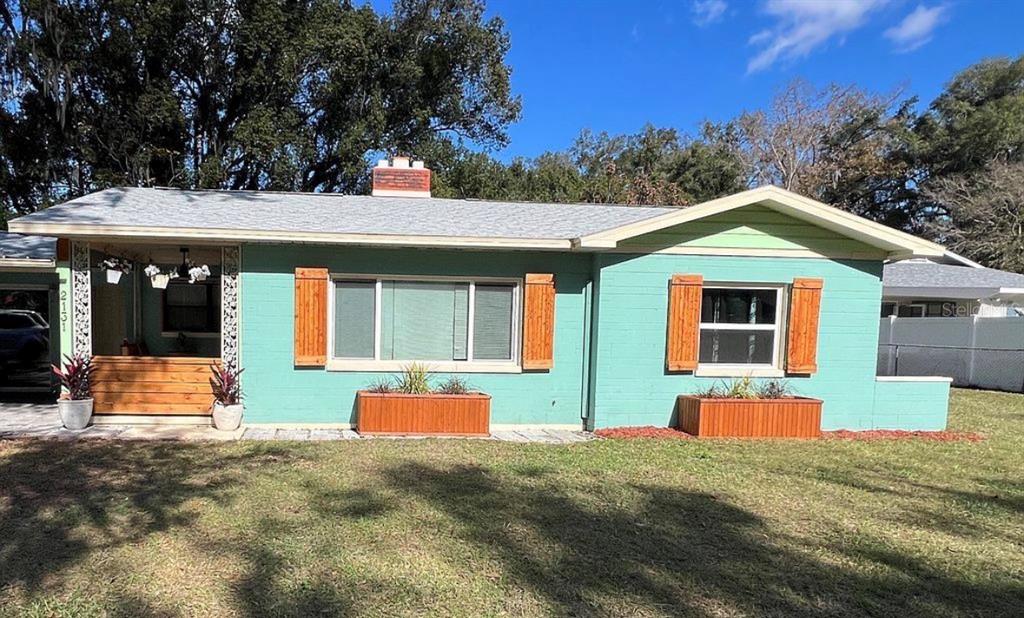 A single-story house with teal painted brick, a front porch, and wooden shutters — 2131 NE 3RD STREET, OCALA, FL