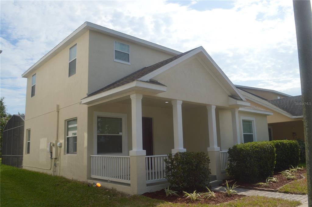 A two-story house with a front porch, white columns, and a tan stucco exterior — 6828 HELMSLEY CIRCLE, WINDERMERE, FL