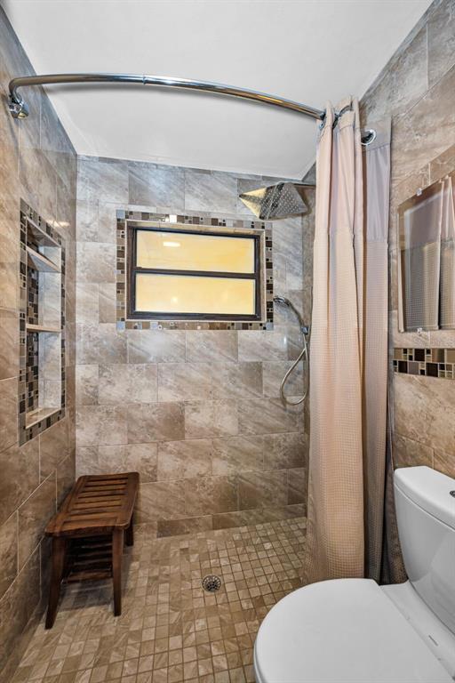 A kitchen features cream cabinets, granite countertops, a brick backsplash, and dark tile flooring — 6701 ORCHARD DRIVE N, ST PETERSBURG, FL