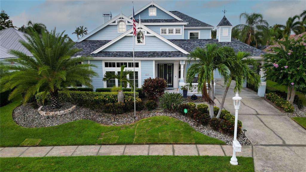 A two-story light blue house with a front porch, palm trees, and a concrete driveway — 4739 PINNACLE DRIVE, BRADENTON, FL