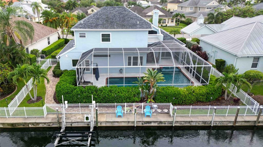 An aerial view of a two-story house with a screened-in pool and canal dock — 4739 PINNACLE DRIVE, BRADENTON, FL