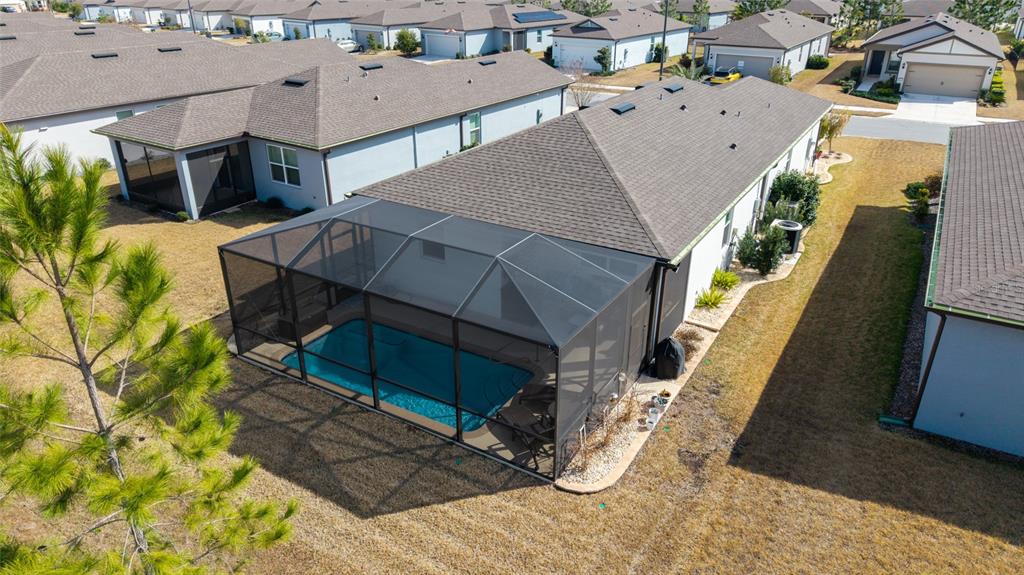 An aerial view shows a house with a screened-in pool and a brown shingled roof — 9419 SW 53RD PLACE, OCALA, FL