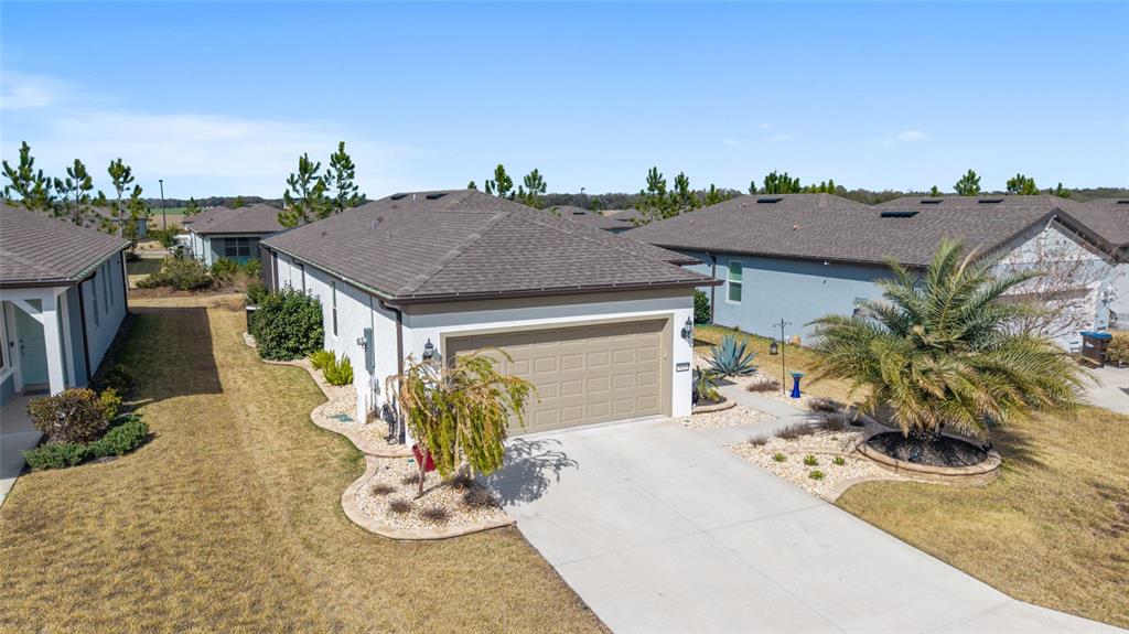 An aerial view shows the exterior of a suburban house with a tan garage — 9419 SW 53RD PLACE, OCALA, FL
