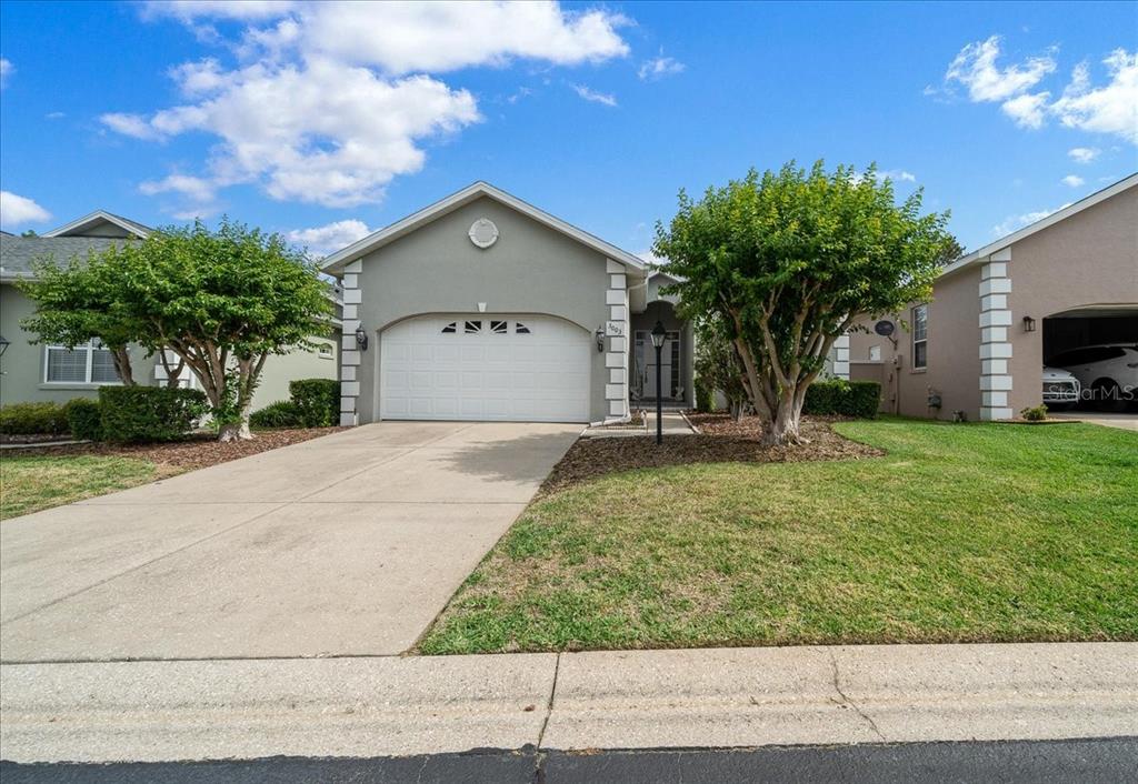 A single-story suburban house features a two-car garage, a concrete driveway, and front landscaping — 3003 SW 41ST PLACE, OCALA, FL