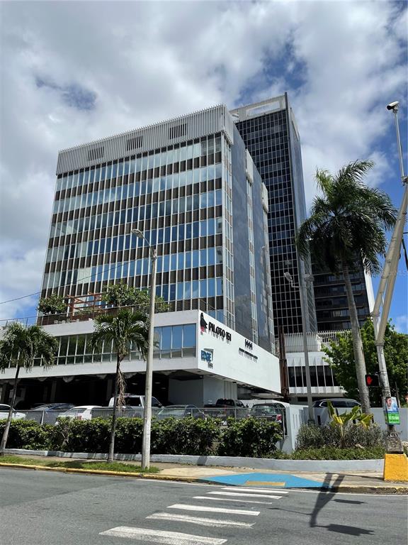 A multi-story office building with a glass facade stands above a parking level and palm trees — 252 PONCE DE LEON AVE, SAN JUAN, PR