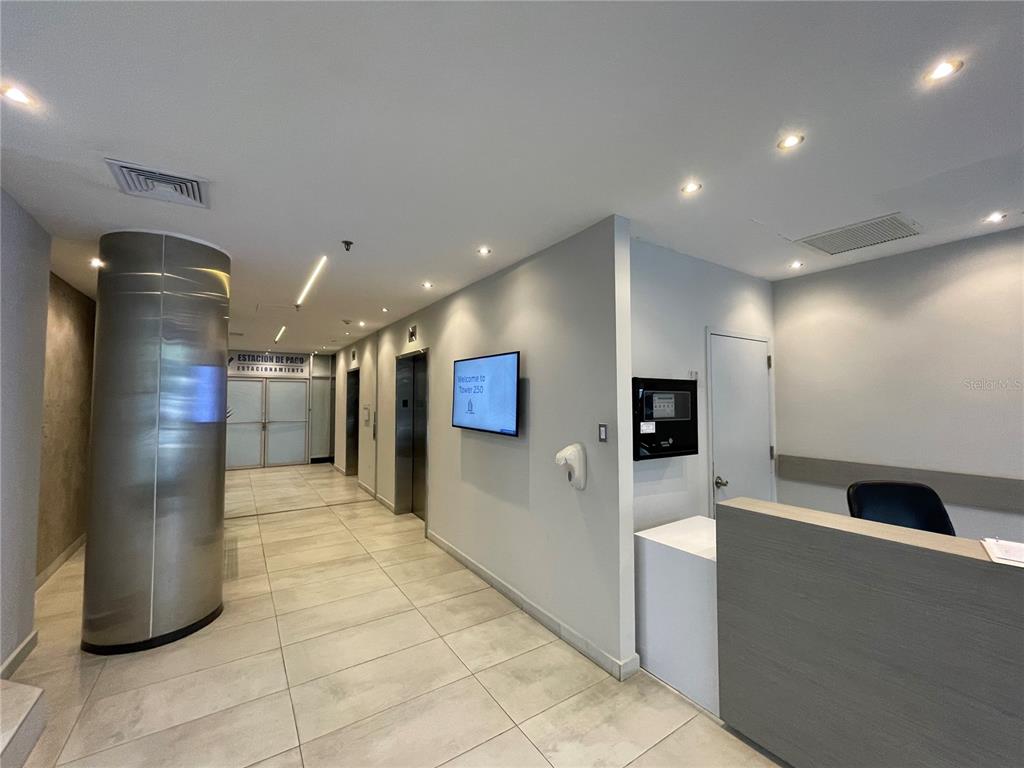 A modern building lobby features a reception desk, elevator bank, and a wall-mounted digital display — 252 PONCE DE LEON AVE, SAN JUAN, PR