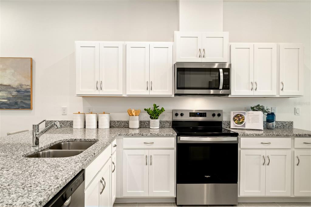 A kitchen featuring white cabinets, granite countertops, and stainless steel appliances — 172 RAINWOOD STREET, GROVELAND, FL