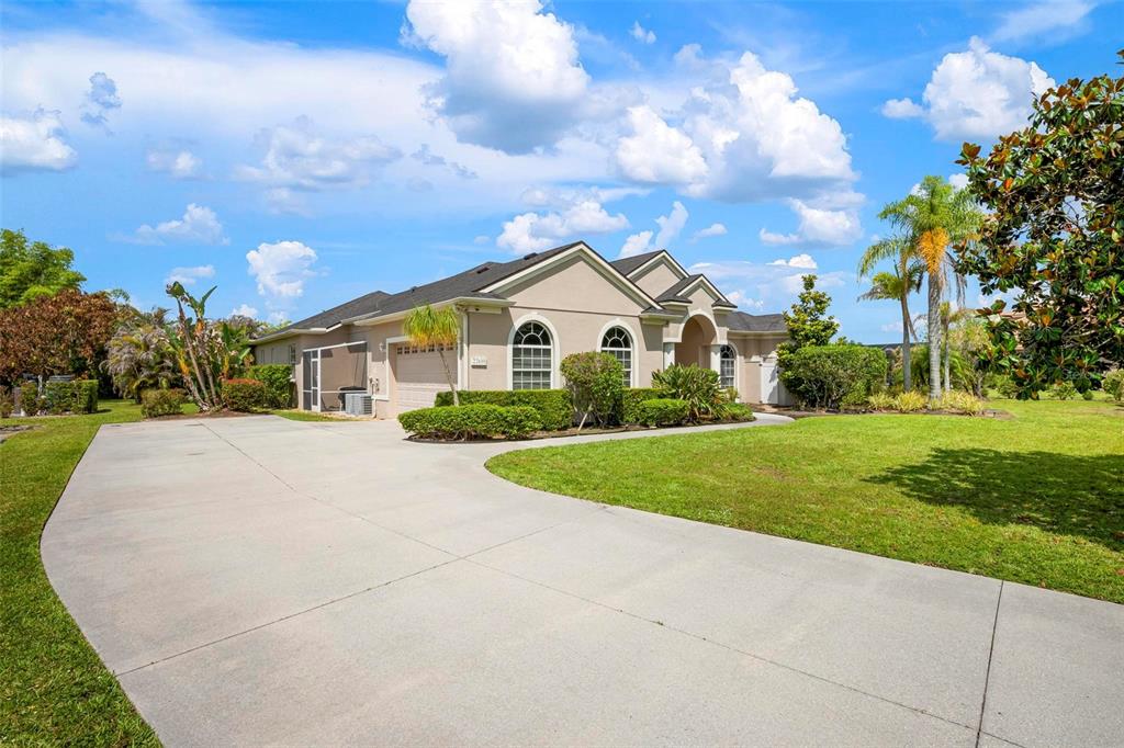 A single-story house with a beige stucco exterior, arched windows, and a manicured front lawn — 22610 NIGHT HERON WAY, BRADENTON, FL