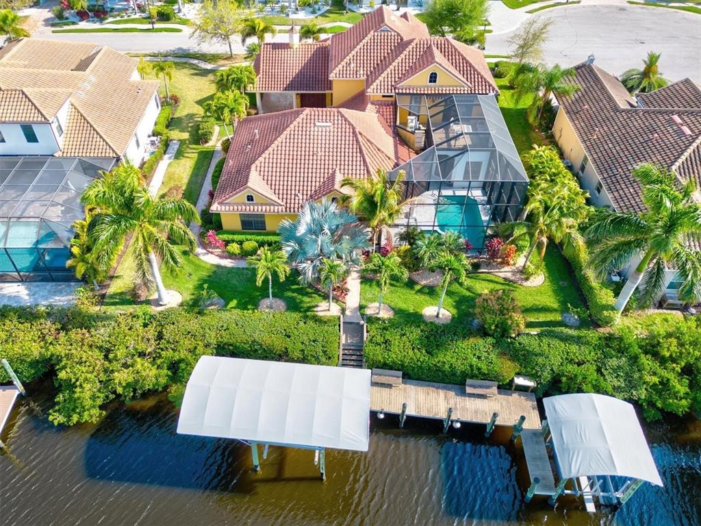 An aerial view of a waterfront house with a pool, screened lanai, and boat dock — 540 FORE DRIVE, BRADENTON, FL