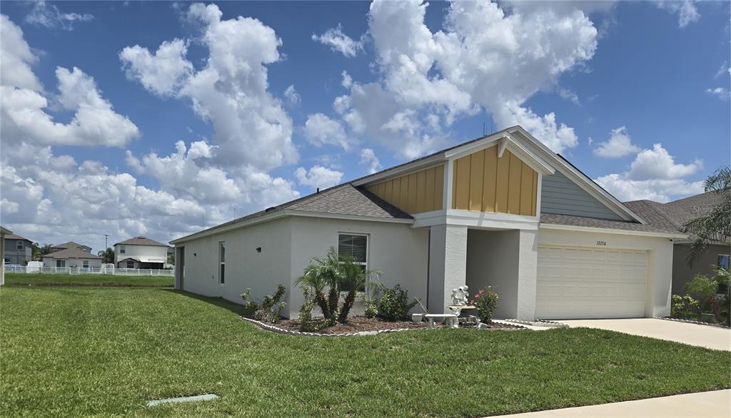 A single-story house with a yellow gable, white stucco walls, and a two-car garage — 12730 MANGROVE FOREST DRIVE, RIVERVIEW, FL