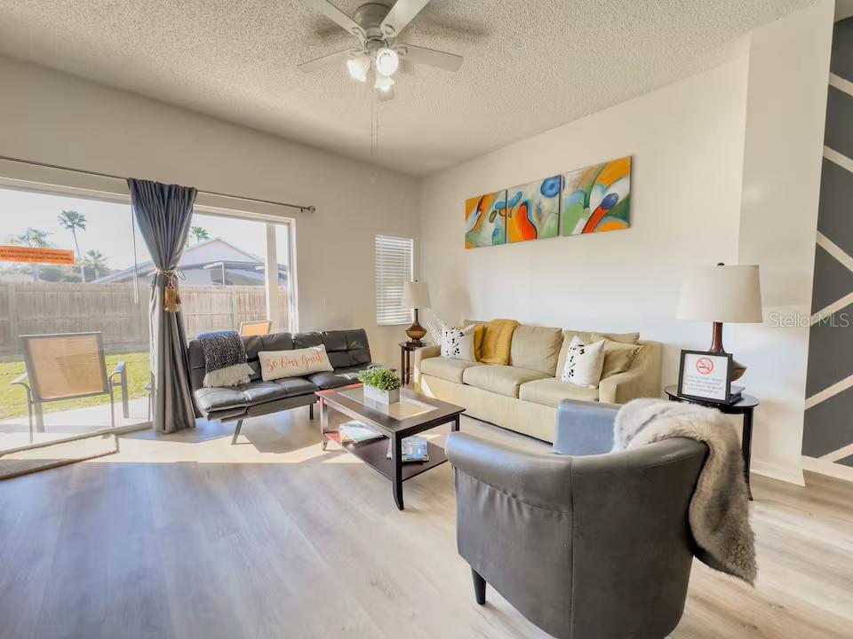 A kitchen features oak cabinets, a stainless steel microwave, a black stove, and gray countertops — 910 PARK TERRACE CIRCLE, KISSIMMEE, FL
