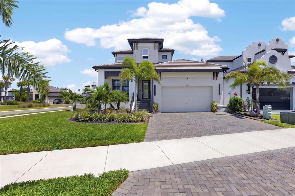 A two-story house with a paved driveway, a two-car garage, and palm trees — 1075 SEAGRAPE DRIVE, RUSKIN, FL