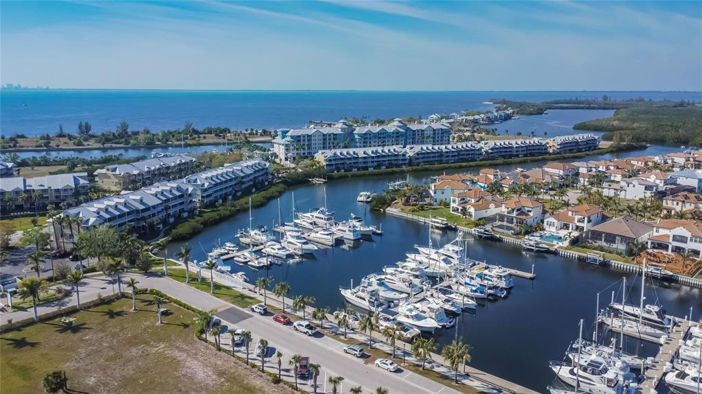An aerial view shows a marina filled with boats next to residential buildings and water — 1075 SEAGRAPE DRIVE, RUSKIN, FL