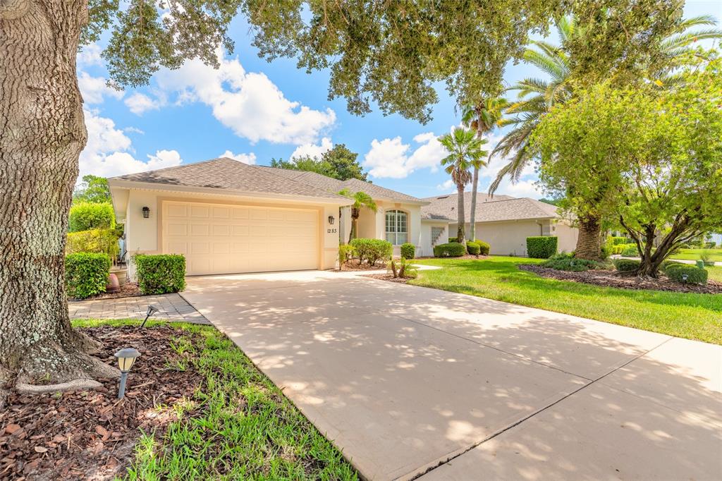 A single-story house with a beige garage and a concrete driveway under a blue sky — 1283 ROYAL POINTE LANE, ORMOND BEACH, FL