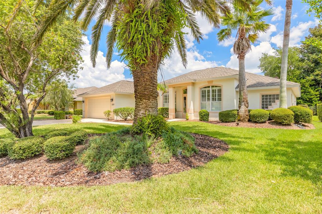 A single-story house with a beige exterior, a two-car garage, and palm trees in front — 1283 ROYAL POINTE LANE, ORMOND BEACH, FL