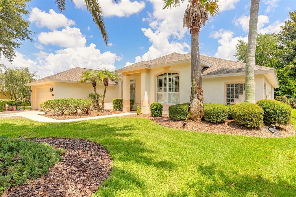A single-story house with a beige exterior, a two-car garage, and a landscaped front yard — 1283 ROYAL POINTE LANE, ORMOND BEACH, FL