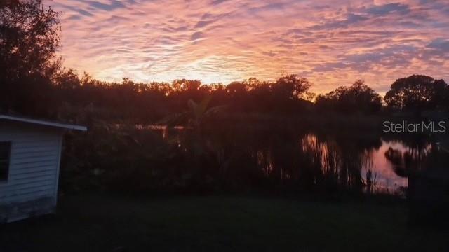 A sunset view over a pond with a small white building in the foreground — 8841 S MOBLEY ROAD, ODESSA, FL