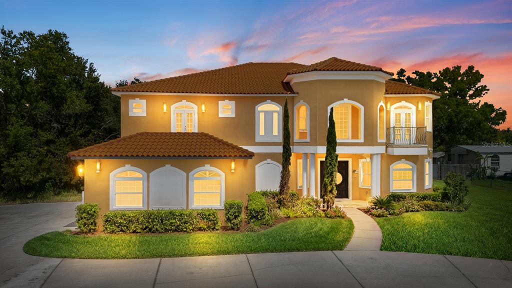 A two-story Mediterranean-style house with a tile roof, stucco exterior, and a landscaped front yard — 11250 MCMULLEN ROAD, RIVERVIEW, FL