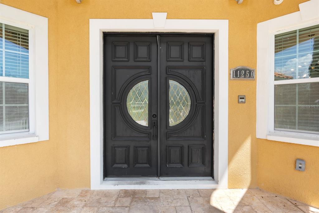 A front entrance features double black doors with circular glass inserts and a stone porch — 11250 MCMULLEN ROAD, RIVERVIEW, FL
