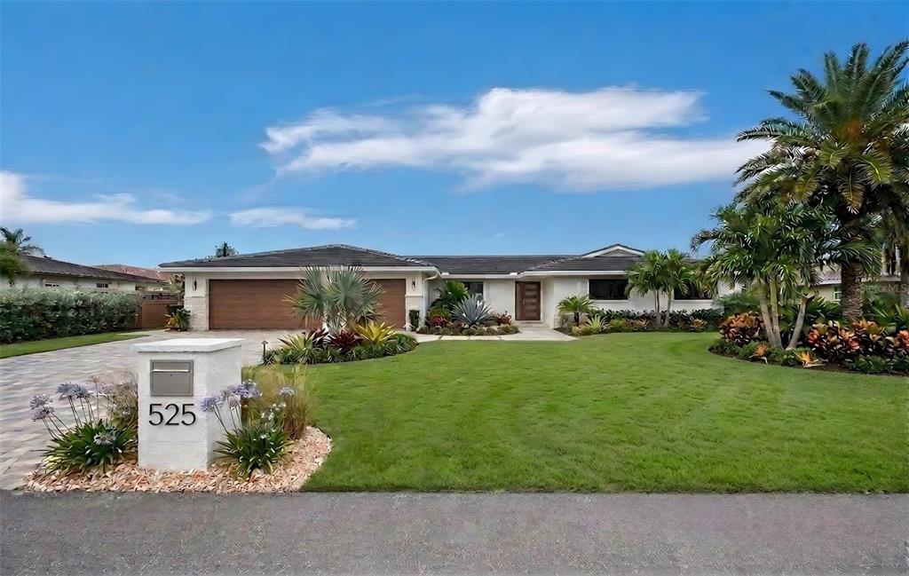 A single-story house with a paved driveway, a two-car garage, and a landscaped front lawn — 525 SLOOP LANE, LONGBOAT KEY, FL