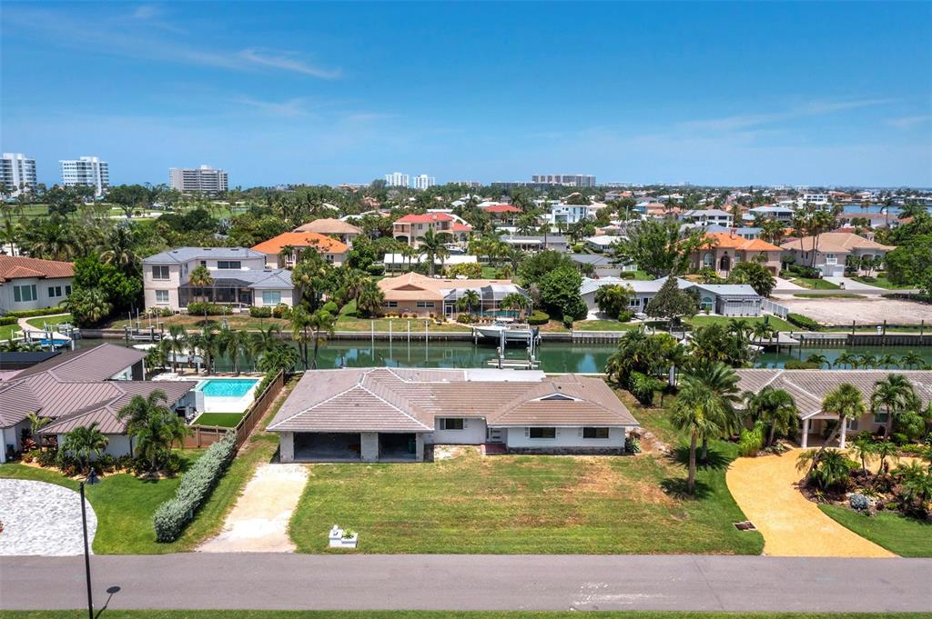 An aerial view shows a single-story house with a canal in the backyard — 525 SLOOP LANE, LONGBOAT KEY, FL