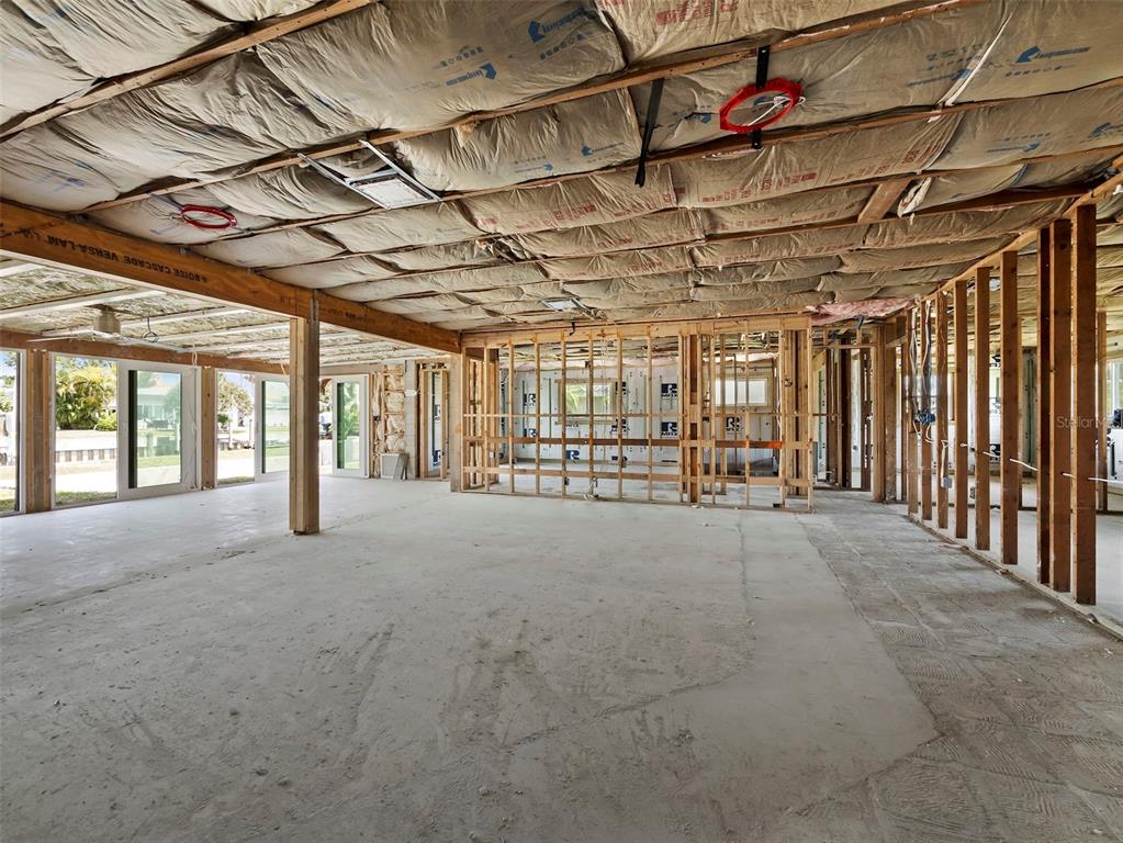 An unfinished interior space features exposed wooden framing, concrete flooring, and fiberglass ceiling insulation — 525 SLOOP LANE, LONGBOAT KEY, FL