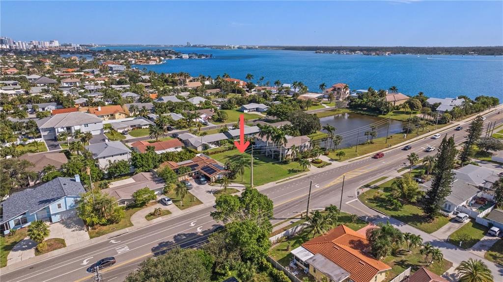 Four aerial views show a three-story modern house with balconies and a ground-level garage — CAUSEWAY BOULEVARD, BELLEAIR BEACH, FL
