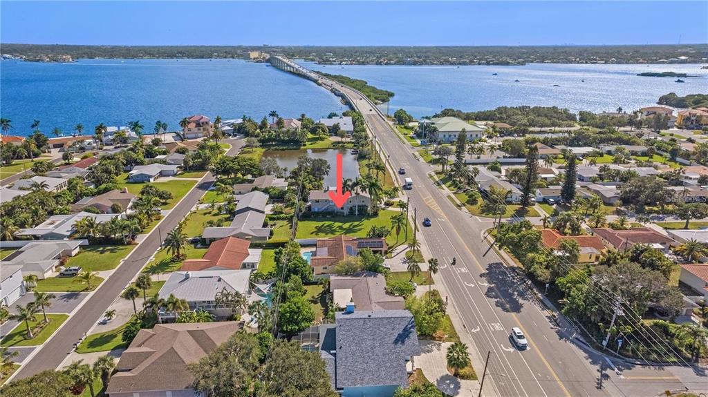 An aerial view shows a residential neighborhood near a long bridge over the water — CAUSEWAY BOULEVARD, BELLEAIR BEACH, FL
