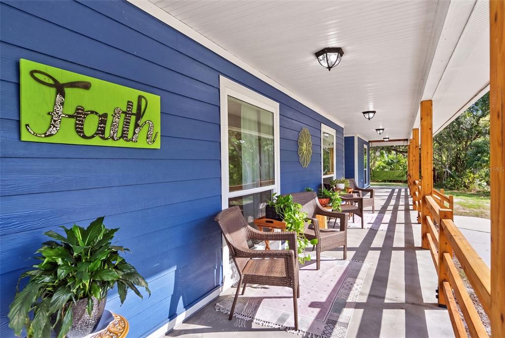 A blue house with a metal roof, lime green double doors, and a covered porch — 9990 SW COUNTY ROAD 769, ARCADIA, FL
